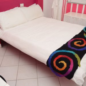 letto trasformabile matrimoniale a parete, vista del letto aperto colorato con righe in continuo sull'intera parete