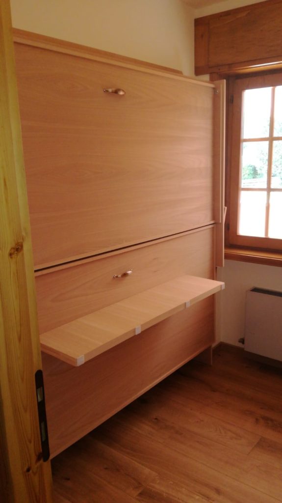 Letto a scomparsa a parete aperto in una camera